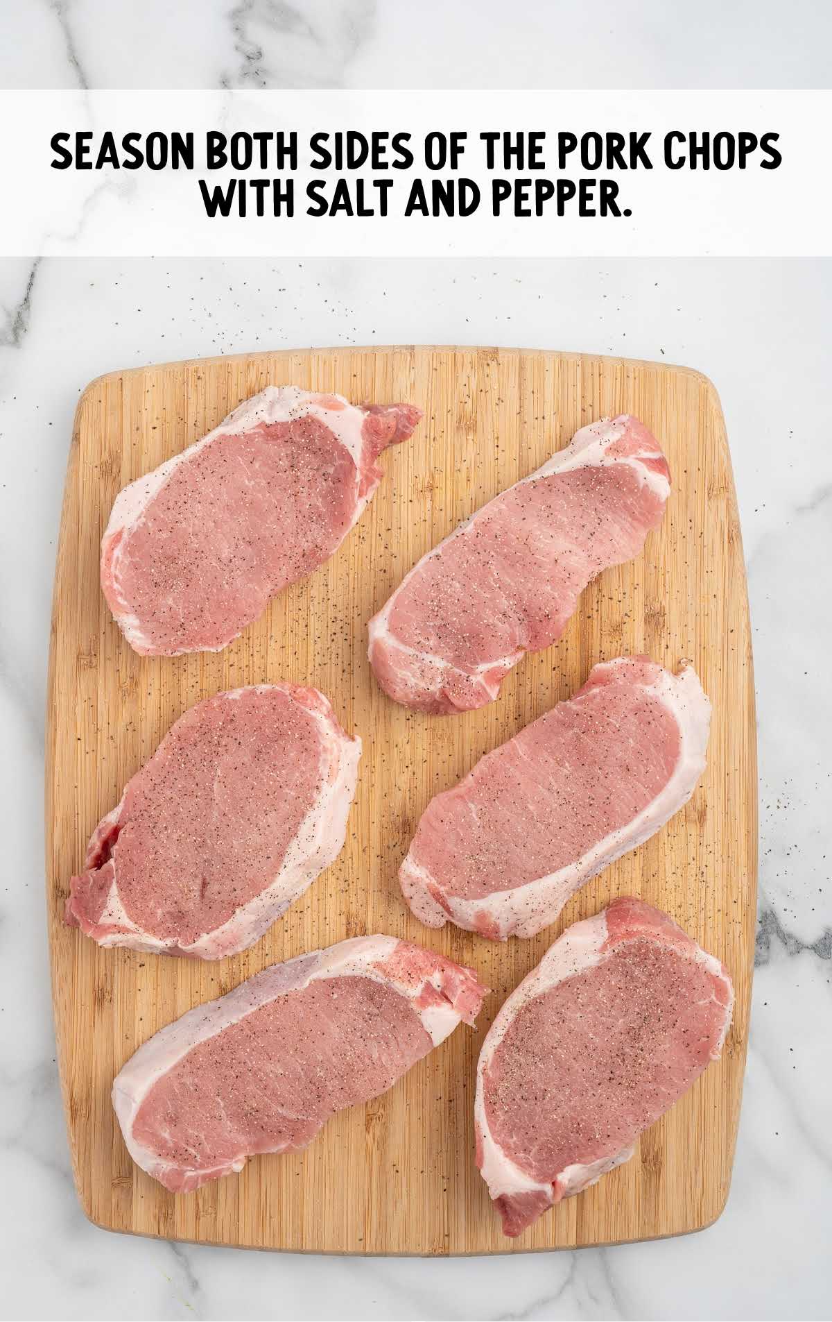 pork chops seasoned with salt and pepper on a wooden board