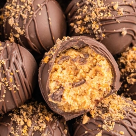 a close up shot of a Butterfinger Balls with one having a bite taken out of it