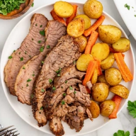 overhead shot shot of slices of Slow Cooker Brisket and potatoes on a plate