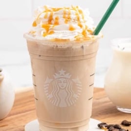 a close up shot of Iced Latte Caramel in a cup topped with whipped cream