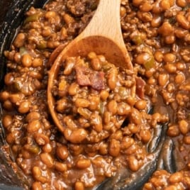 a skillet of Baked Beans with Ground Beef garnished with green onions