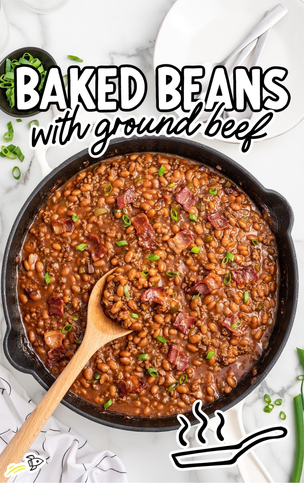 a skillet of Baked Beans with Ground Beef garnished with green onions