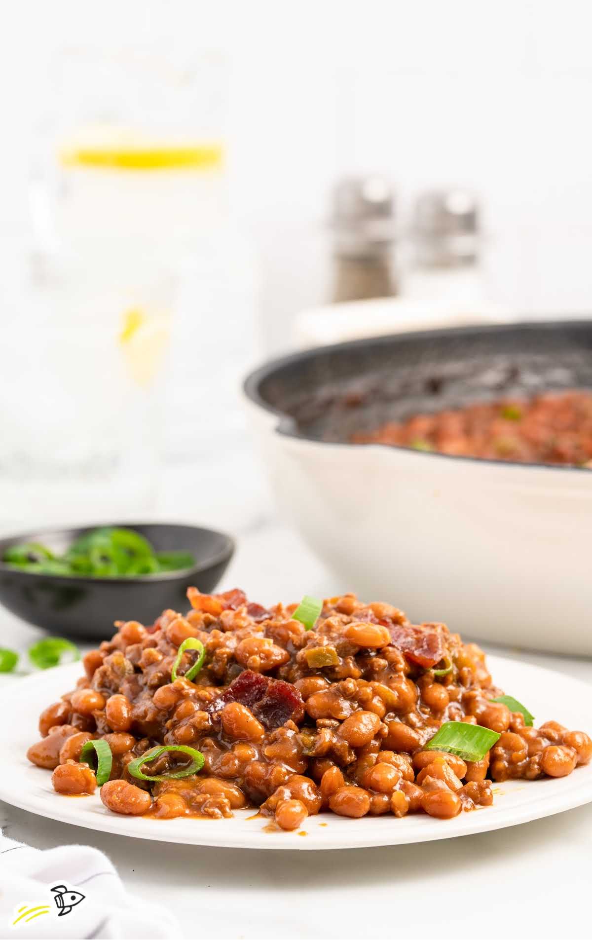 a plate of Baked Beans with Ground Beef garnished with green onions