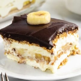 a slice of Banana Eclair Cake topped with a slice of banana on a plate