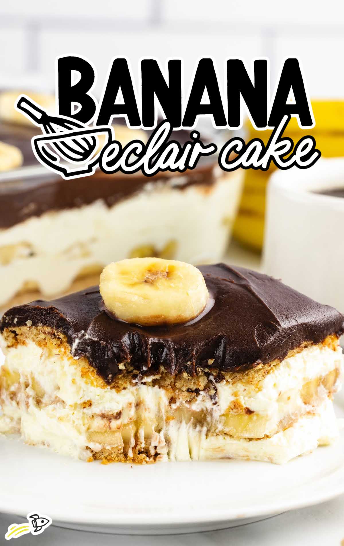 a slice of Banana Eclair Cake topped with a slice of banana on a plate