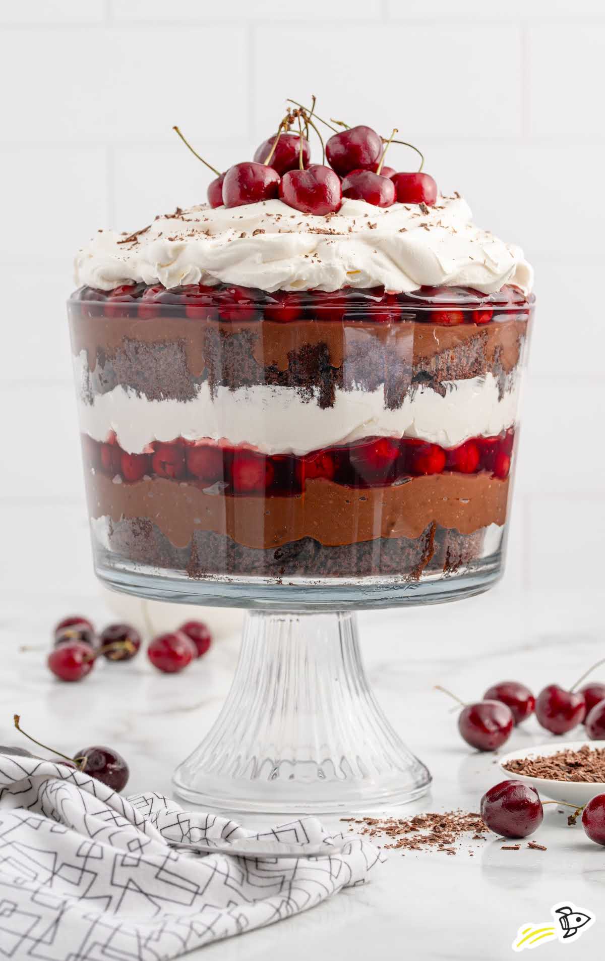 a jar of Black Forest Trifle topped with whipped topping, chocolate shavings, and cherries