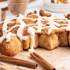 Cinnamon Pull Apart Bread on a wooden board with cinnamon sticks