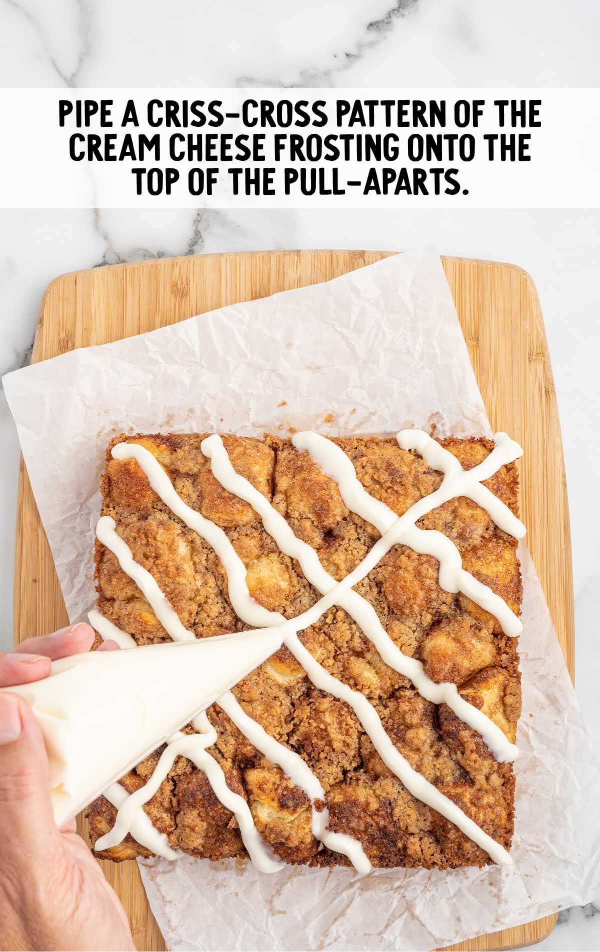 criss-cross pattern of the cream cheese frosting piped over the top of the cinnamon bread