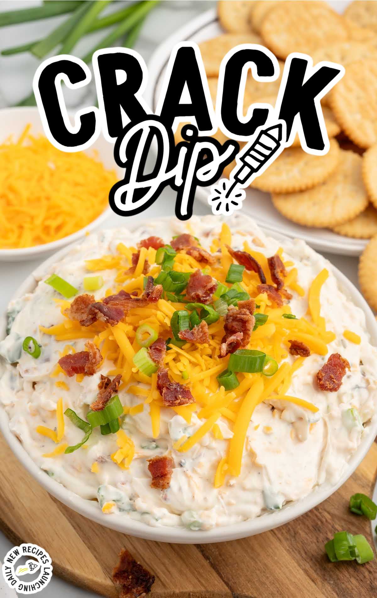 a bowl of Crack Dip topped with shredded cheese, bacon bits, and green onions