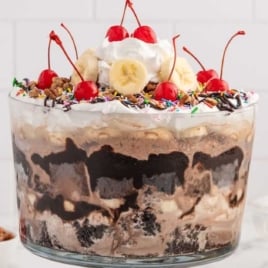a jar of Ice Cream Trifle topped with sprinkles, banana slices, cherries, and whipped topping