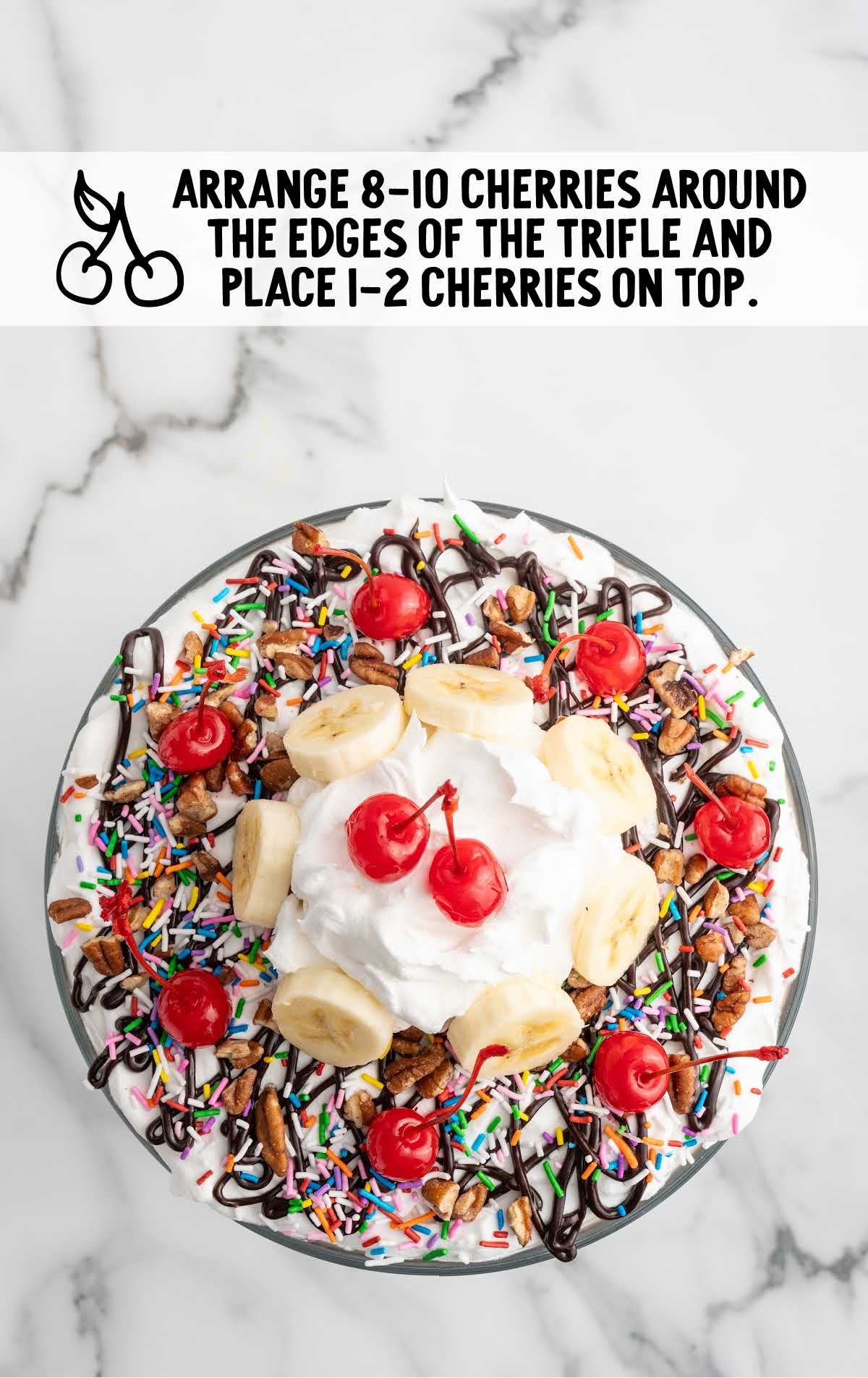 Ice Cream Trifle topped with sprinkles, banana slices, cherries, and whipped topping