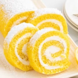 slices of Lemon Swiss Roll sprinkled with powdered sugar on a plate