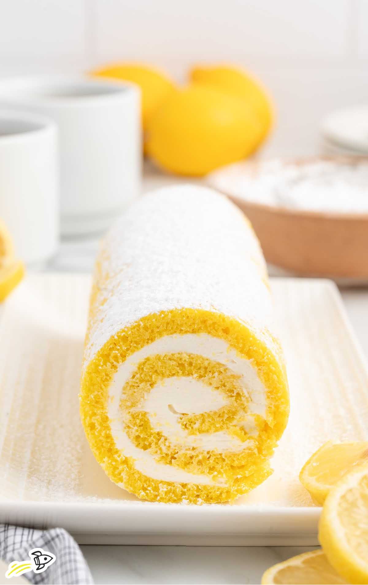 a Lemon Swiss Roll sprinkled with powdered sugar on a plate