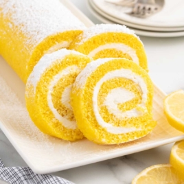 slices of Lemon Swiss Roll sprinkled with powdered sugar on a plate