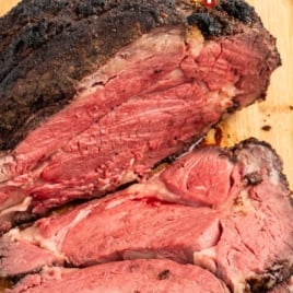 a cooked prime rib sliced on a wooden board