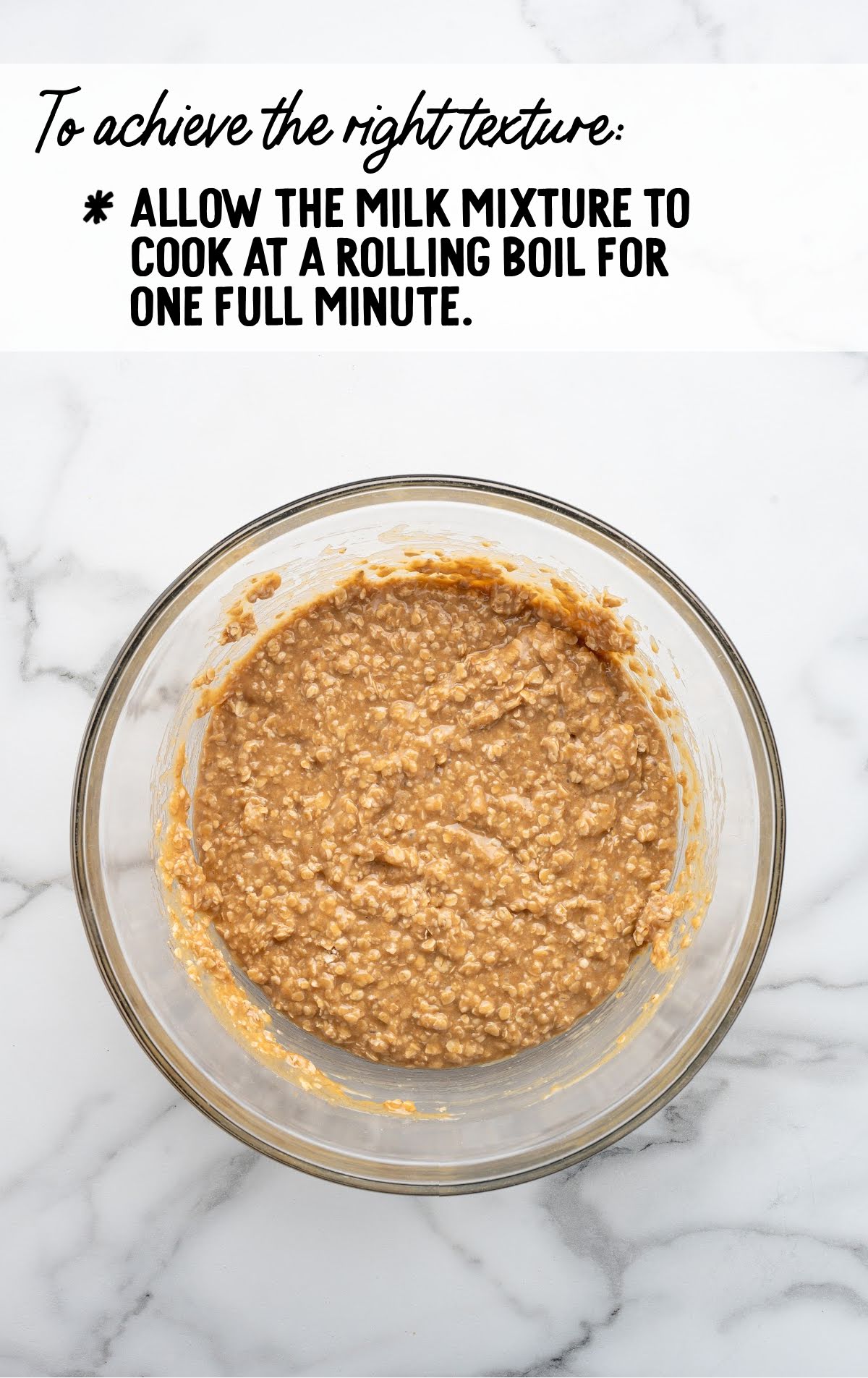 Overhead view of a glass bowl filled with no-bake peanut butter cookie mixture, with a text overlay reminding to boil the milk mixture for one full minute to ensure the right texture."