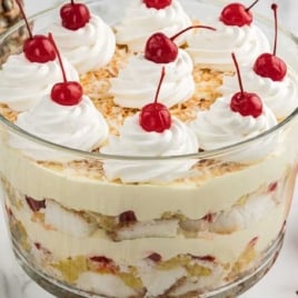 Pina Colada Trifle topped with whipped topping and cherries in a jar