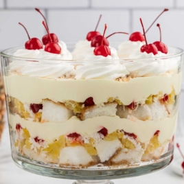 Pina Colada Trifle topped with whipped topping and cherries in a jar