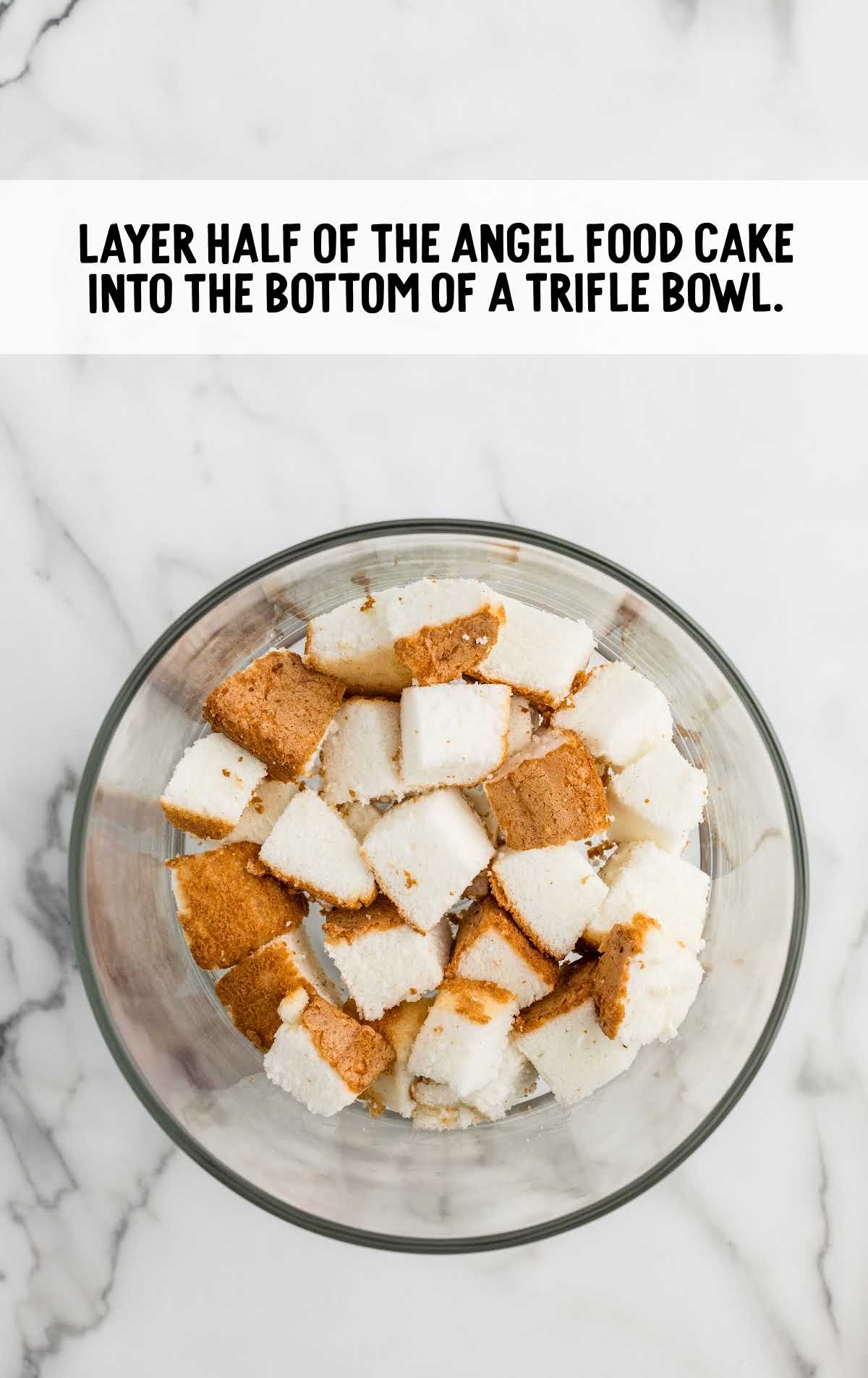 angel food cake cubes added to the bottom of a large trifle bowl