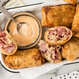 Reuben Eggrolls with a bowl of thousand island dressing on a plate