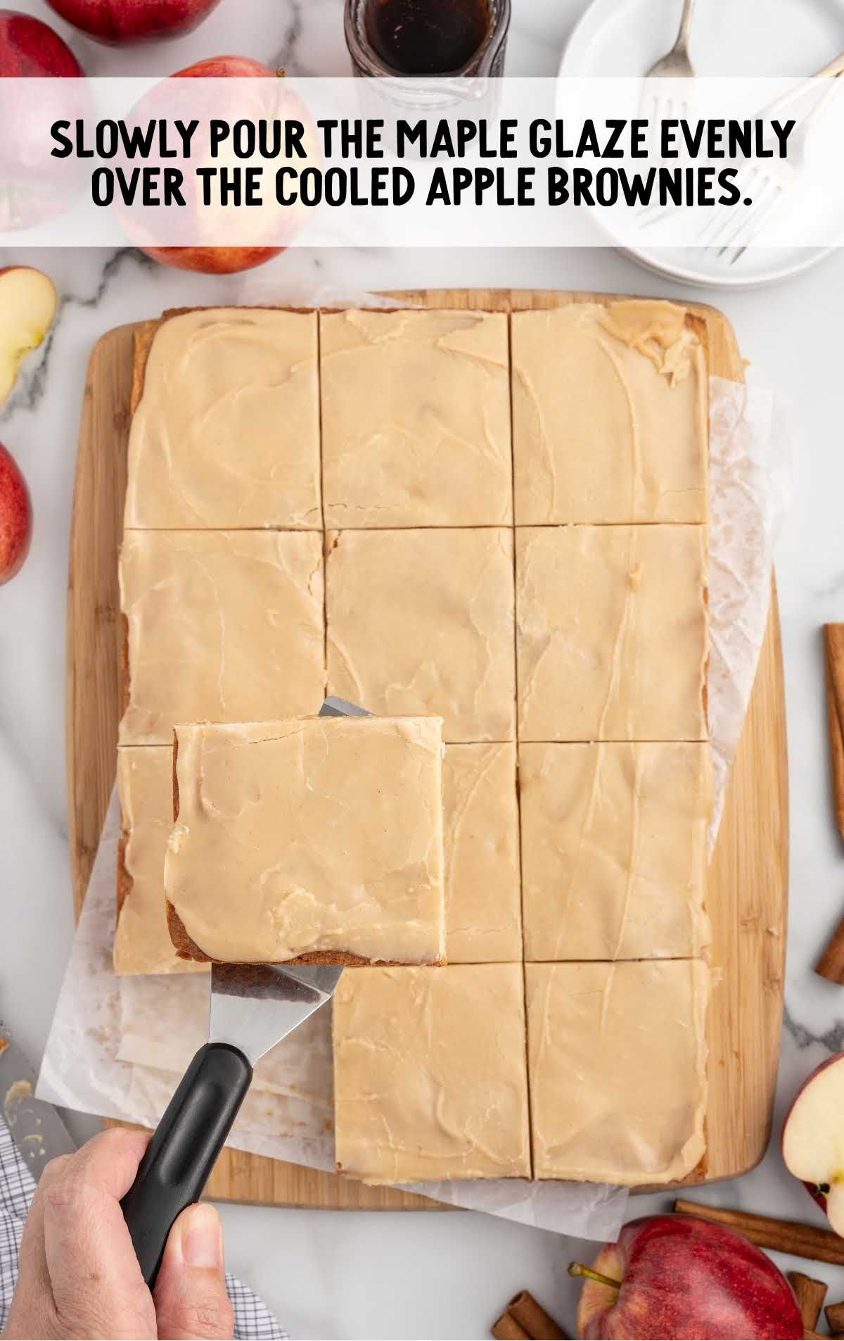 maple glaze poured evenly over the apple brownies