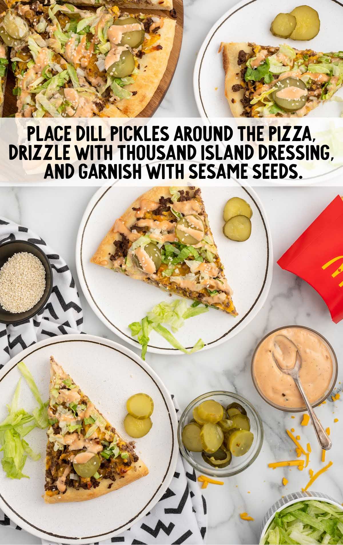 Big Mac Pizza topped with dill pickle slices, Thousand Island dressing, and sesame seeds.