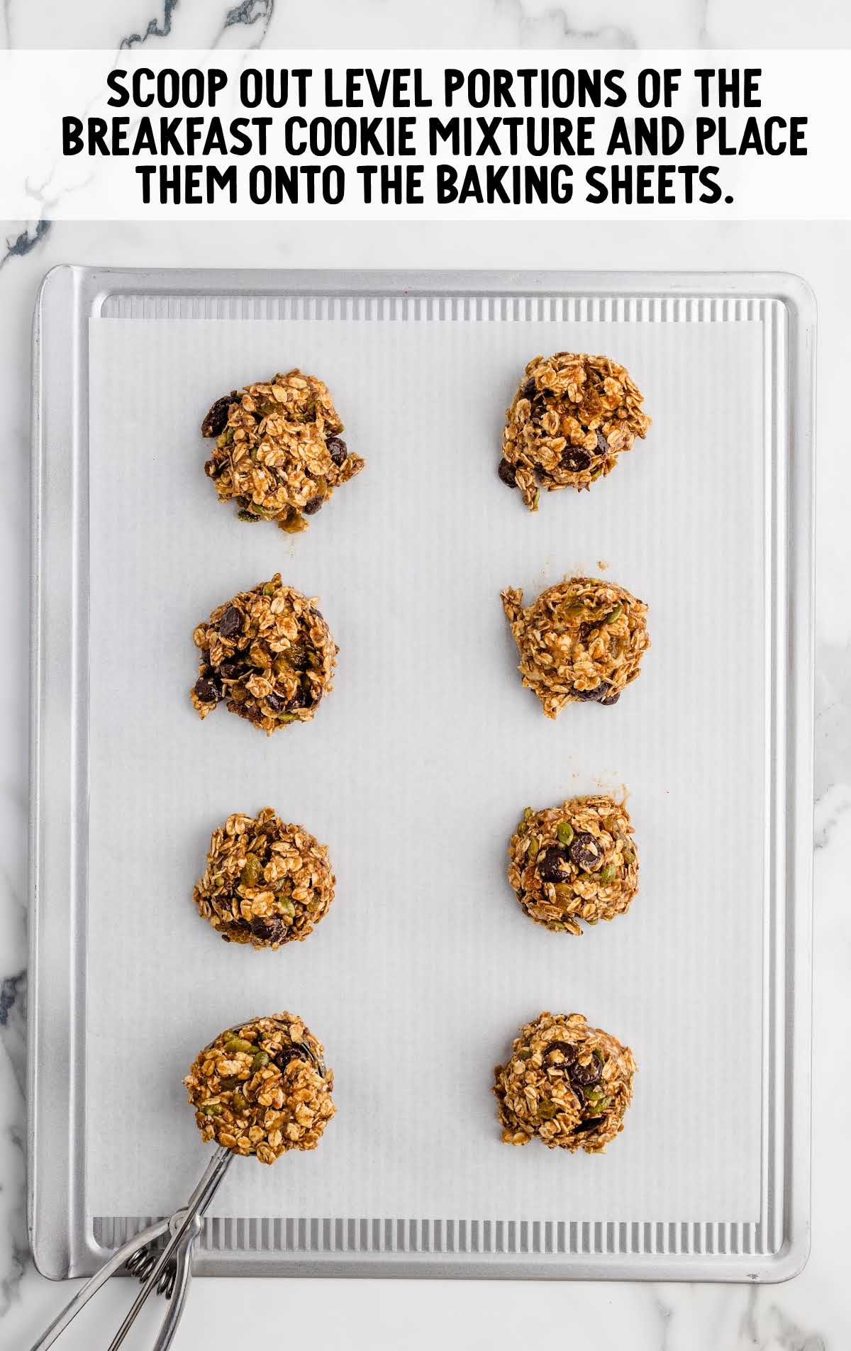 cookie dough scooped onto a parchment lined baking sheet