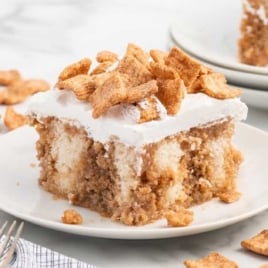 a slice of Cinnamon Toast Crunch Poke Cake on a plate