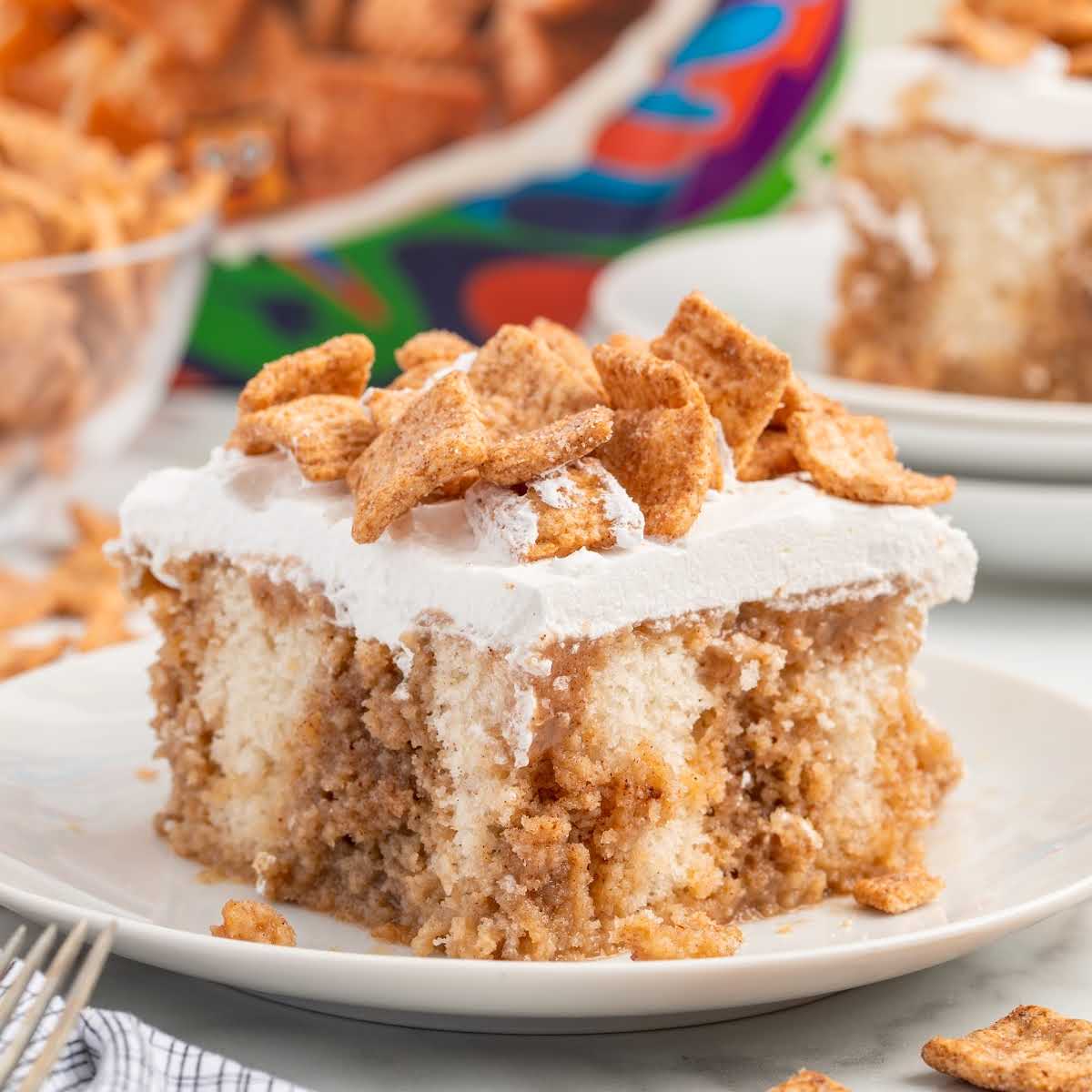 a slice of Cinnamon Toast Crunch Poke Cake on a plate