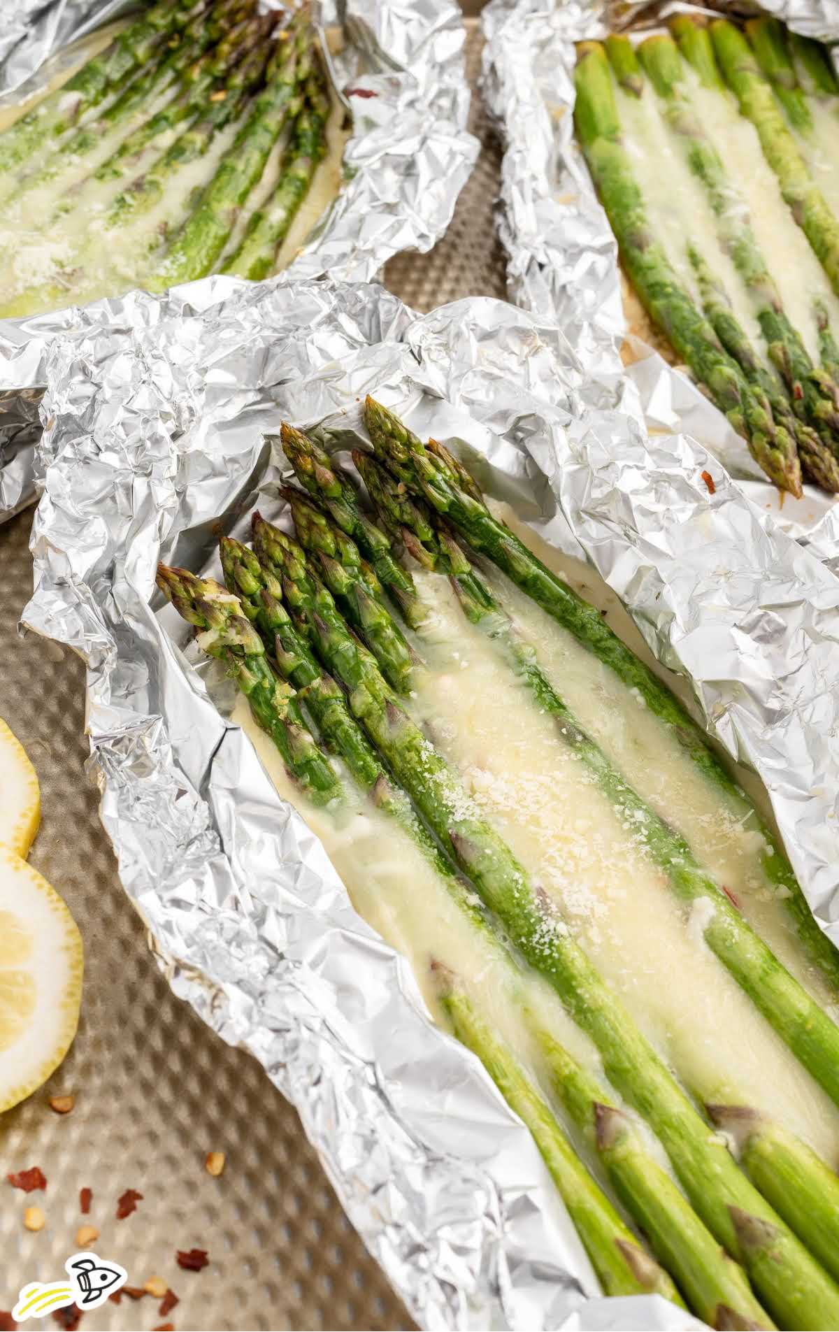 asparagus topped with melted mozzarella cheese in foil