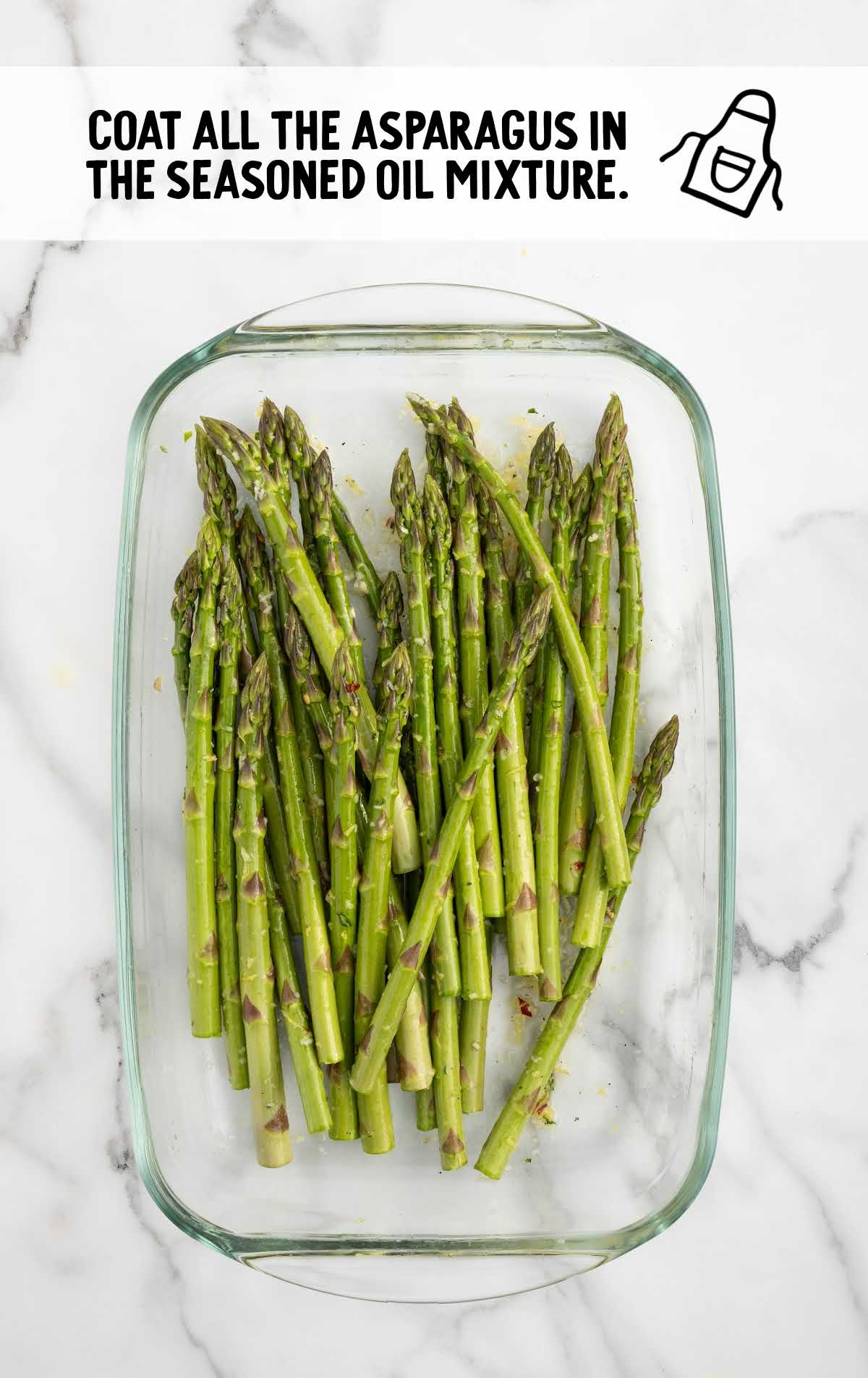 seasoned oil mixture poured over the asparagus in a baking dish