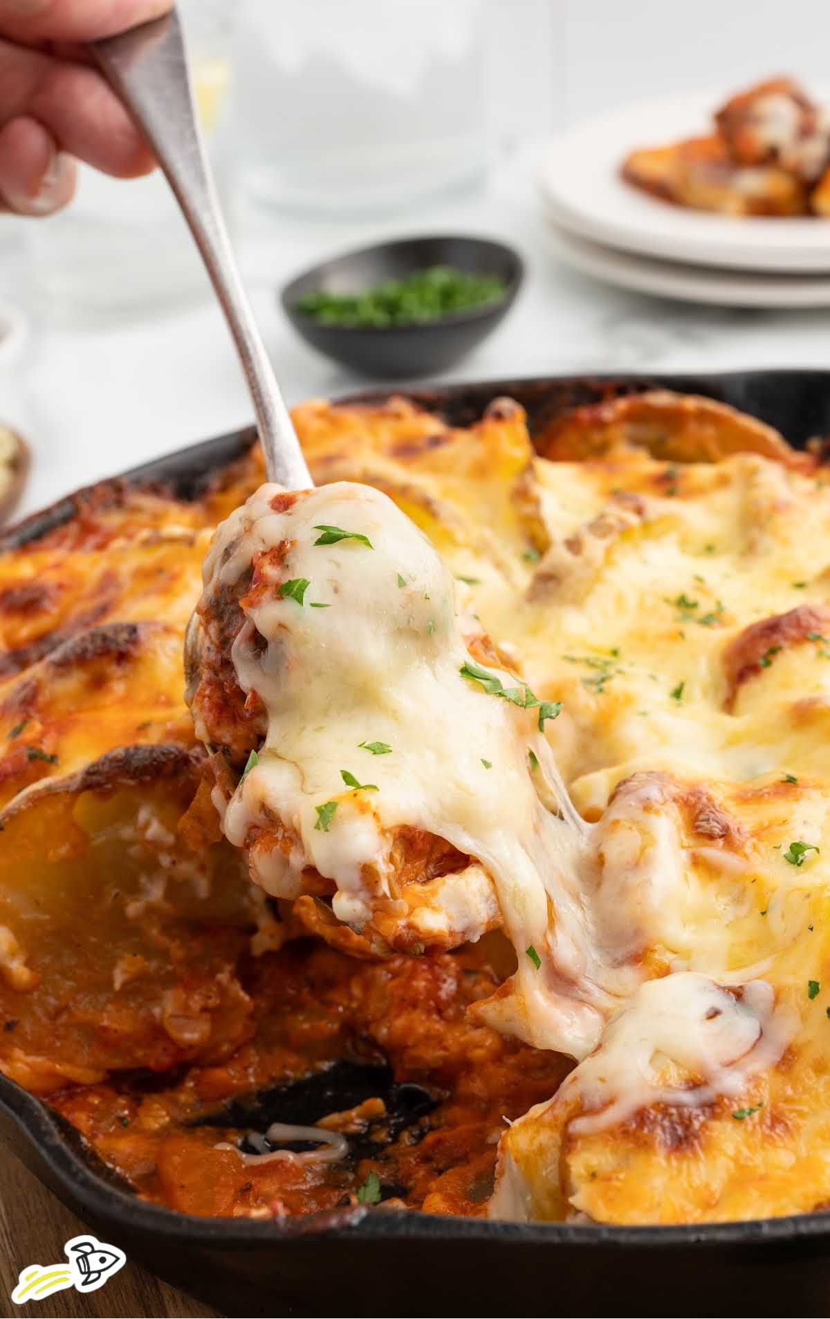 a skillet of Meatballs and Potatoes garnished with parsley