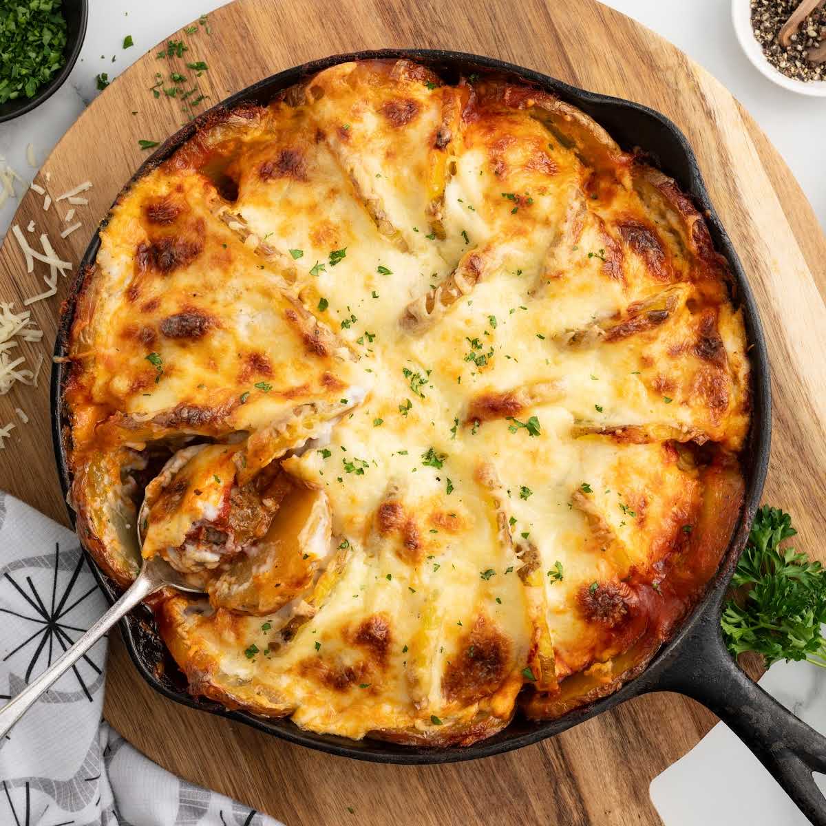 a skillet of Meatballs and Potatoes garnished with parsley
