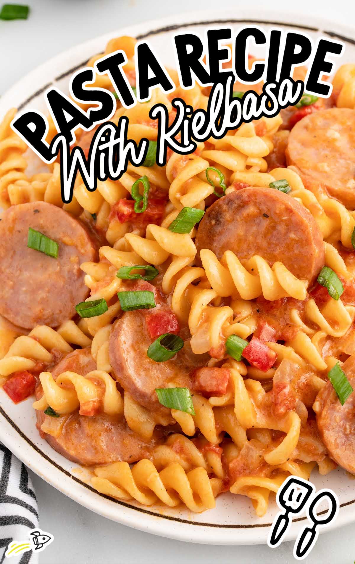 a plate of Kielbasa pasta garnished with green onions