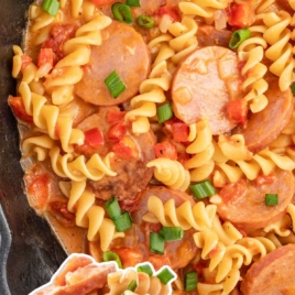 a skillet of Kielbasa pasta garnished with green onions