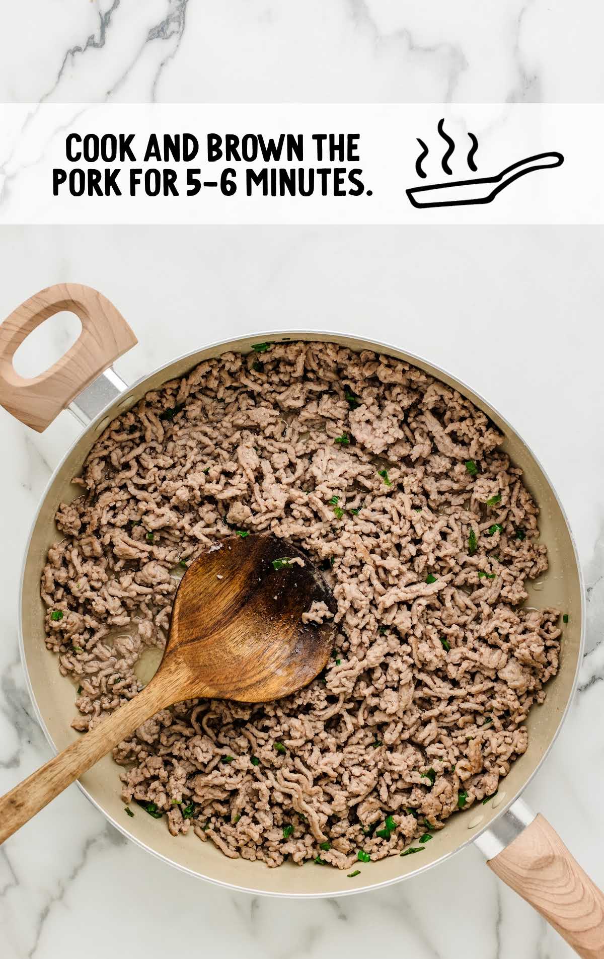 pork and green onions being cooked on a skillet