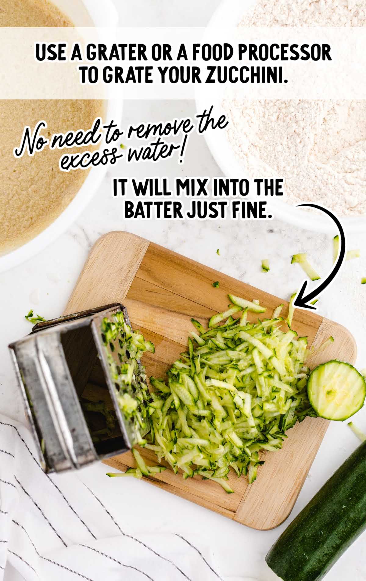 Grated zucchini on a wooden cutting board beside a grater with a note indicating no need to remove excess moisture.