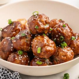 A bowl of turkey meatballs garnished with chopped green onion.