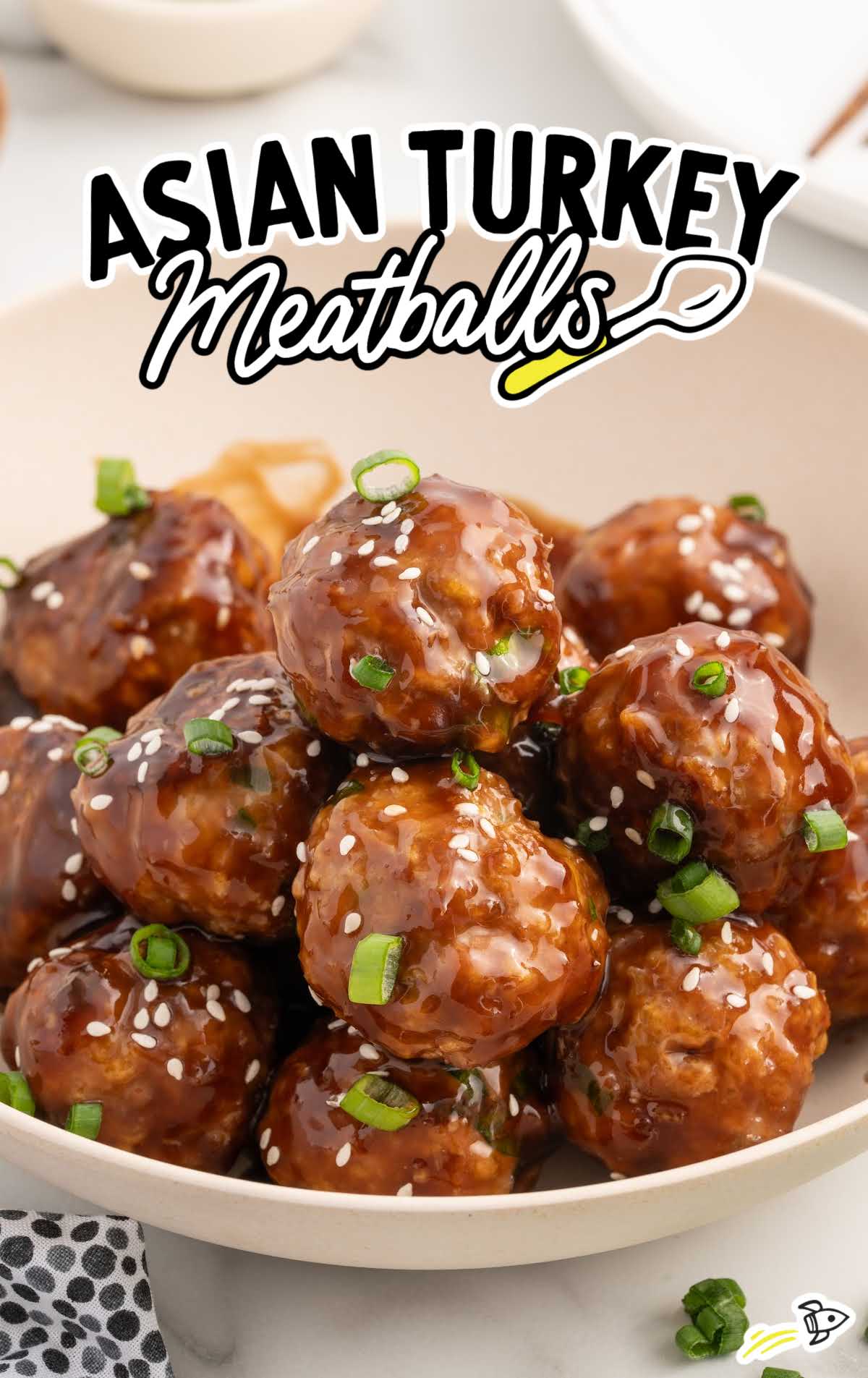 a plate of Asian Turkey Meatballs garnished with green onions and sesame seeds