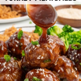 a plate of Asian Turkey Meatballs garnished with green onions and sesame seeds served with rice and broccoli