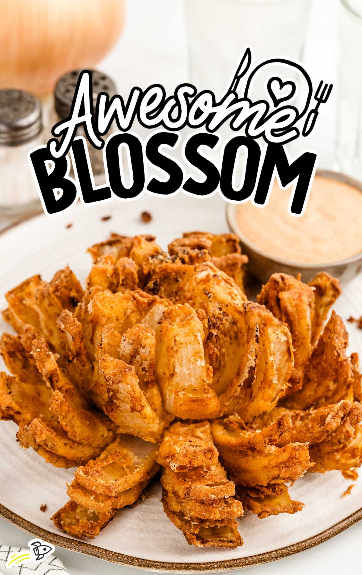 a plate of Awesome Blossom with a bowl of dipping sauce