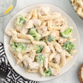 A plate of chicken and broccoli penne alfredo