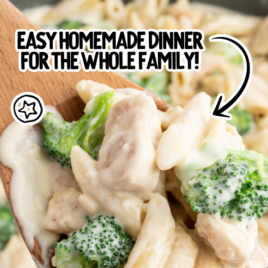 A saute pan is full of chicken broccoli penne alfredo.