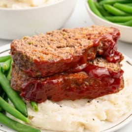 meatloaf served with mashed potatoes and green beans on a plate