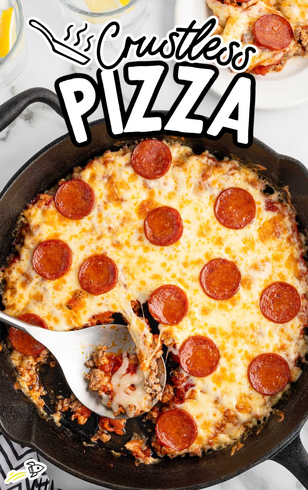 Crustless pizza in a skillet with text overlay reading "Crustless Pizza" and a metal spoon lifting a cheesy serving.