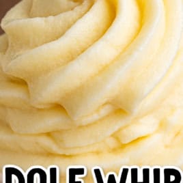 A close-up of creamy yellow Dole Whip soft serve in a white cup, with โDOLE WHIP Disney Recipeโ written in playful black and white text over the image, perfectly capturing the irresistible appeal of this classic Dole Whip recipe.