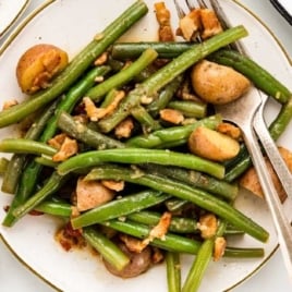 a plate of green beans and potatoes with a fork