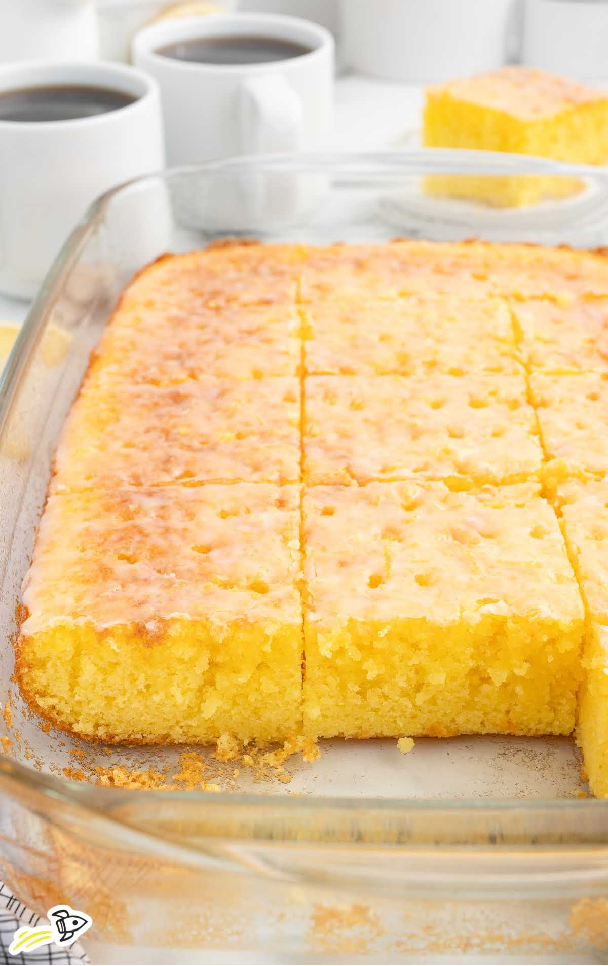 a baking dish of Lemon Jello Cake with a few slices missing