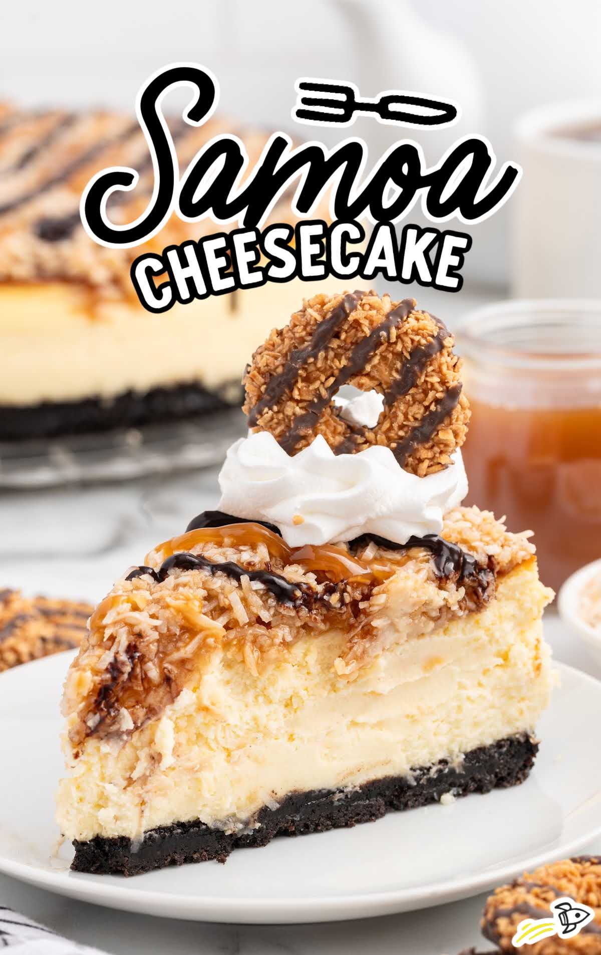 a slice of Samoa Cheesecake topped with whipped topping and samoa cookies on a plate