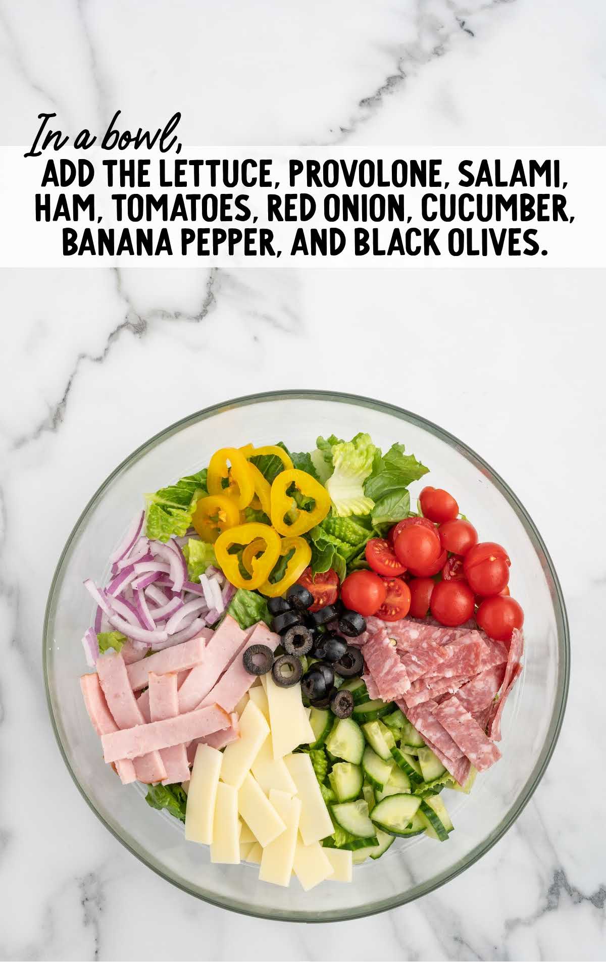 lettuce, provolone, salami, ham, tomatoes, red onion, cucumber, banana pepper, and black olives combined to a bowl